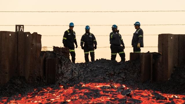 construction workers looking at molten stuff